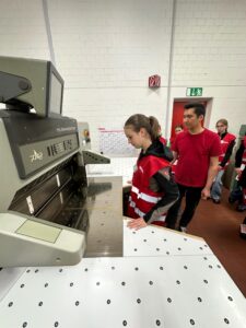 Ein Mädchen darf die Schneidemaschine verwenden