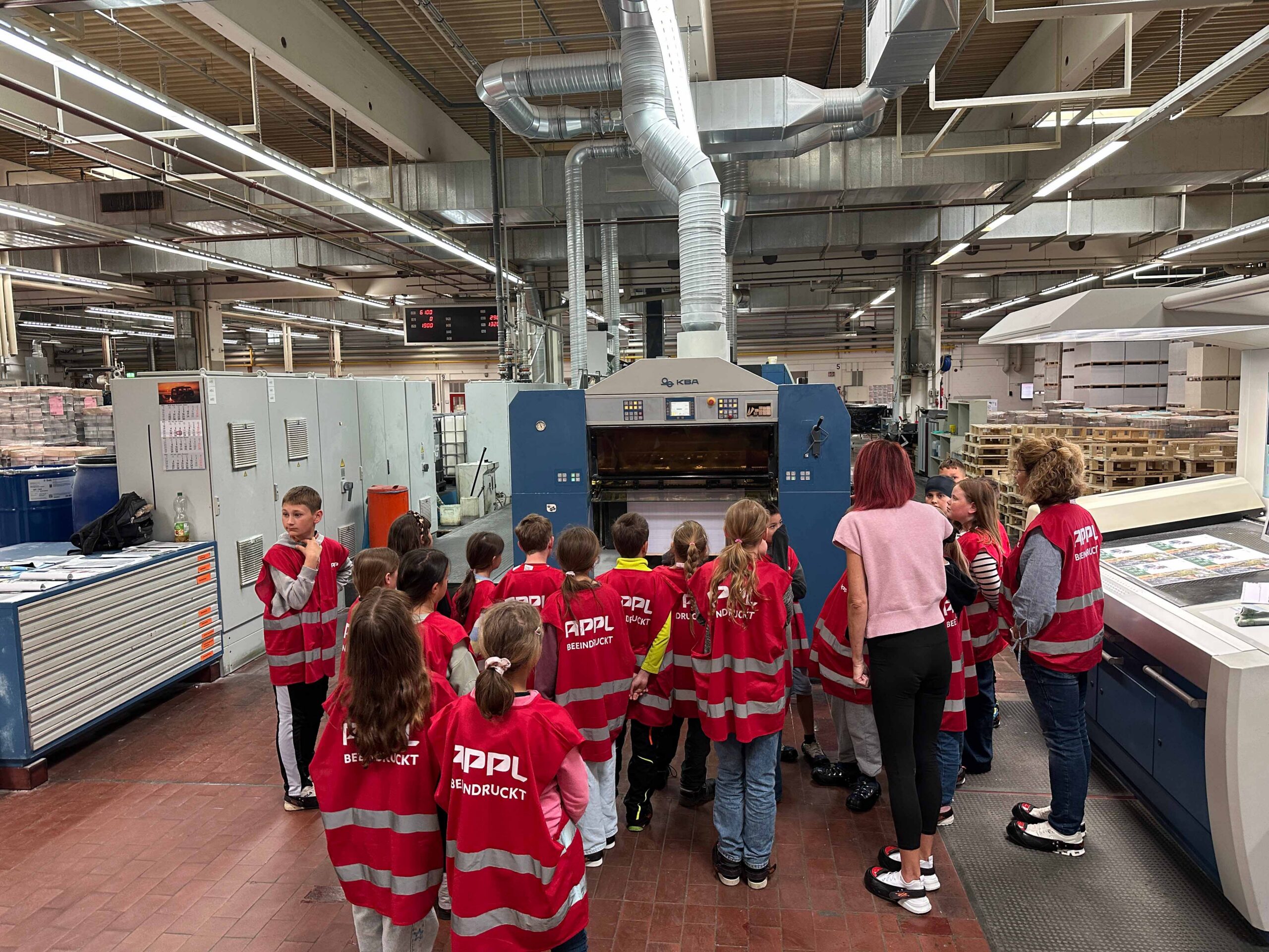 Kinder stehen vor Druckmaschine